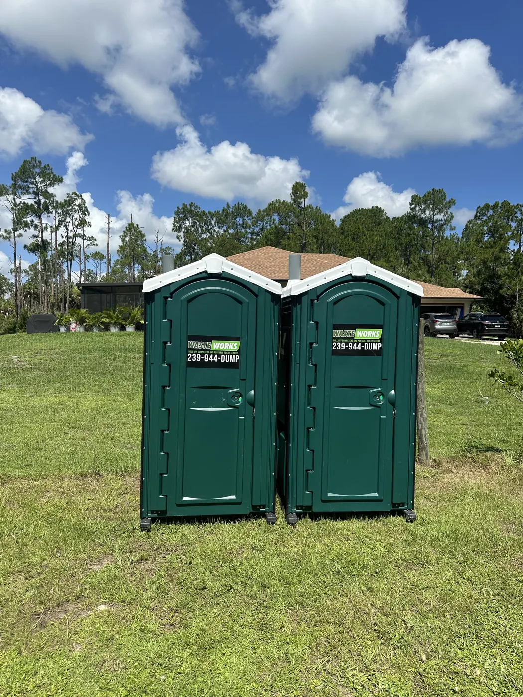 A pair of Waste Works portable toilets on a grass placement area